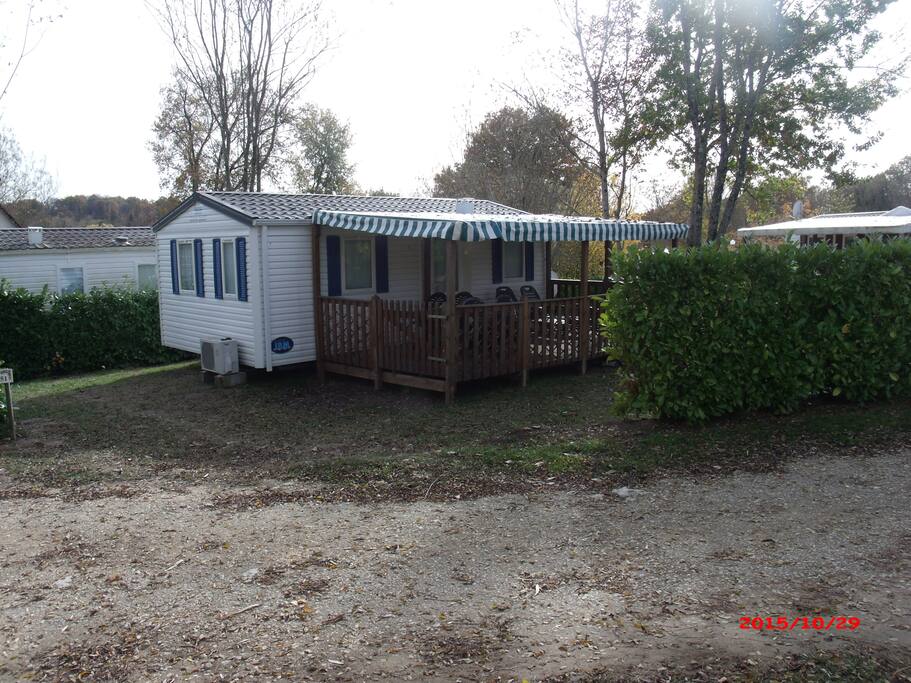 Mobil home en retrait offrant en profondeur un grand espace ombragé et de verdure pour le farniente
