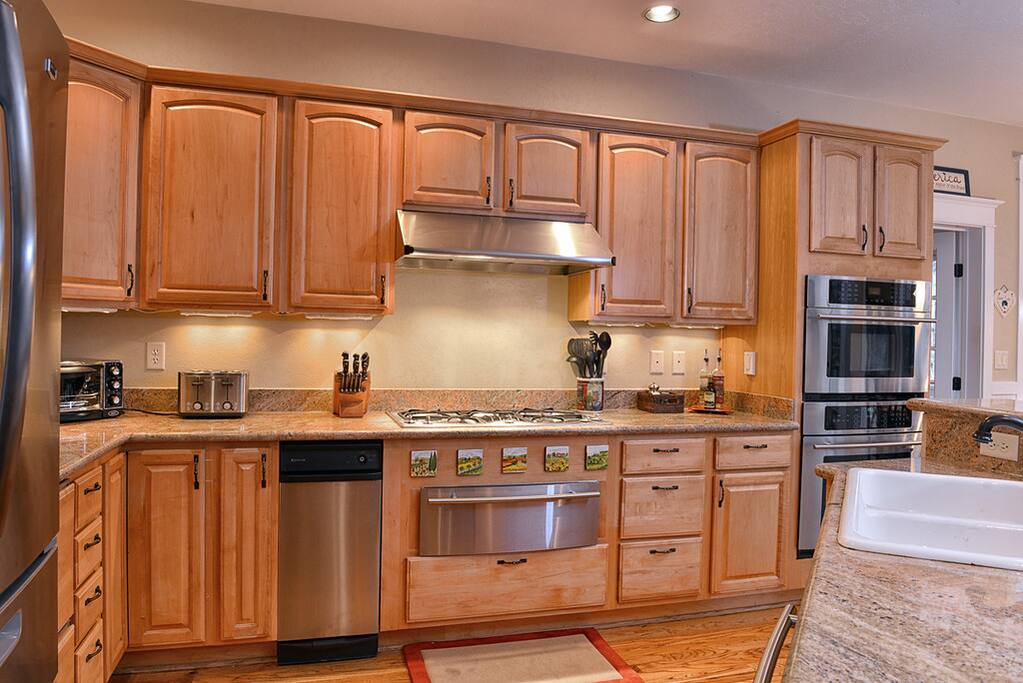 Gourmet kitchen with stainless steel appliances, granite counters, and double oven.