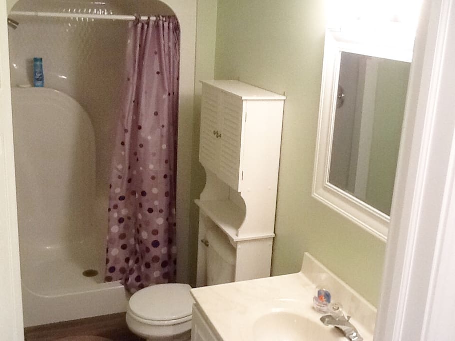 Clean bathroom with single vanity and large standup shower.