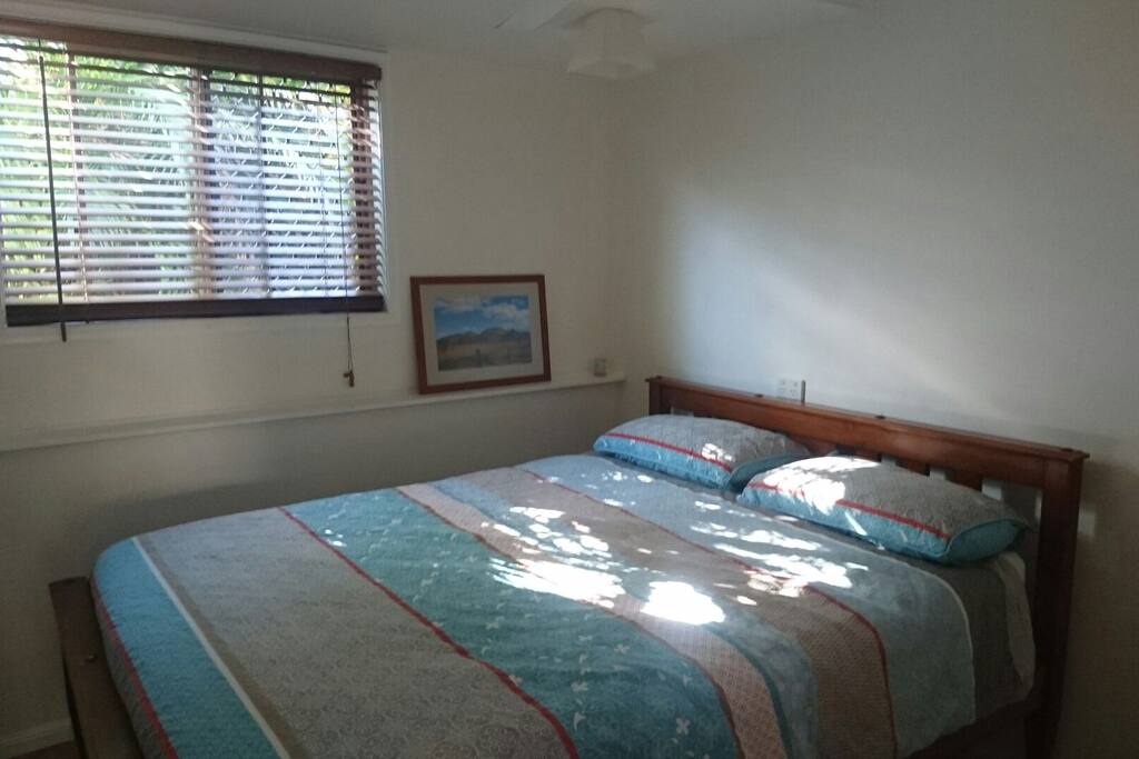 Freshly made queen size bed on arrival with ceiling fan and wardrobe.