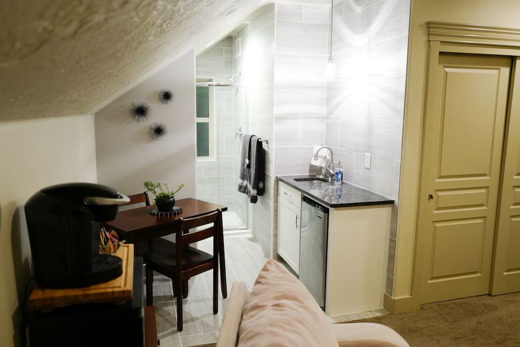 A view of the table, Keurig, and a peek of the bathroom.