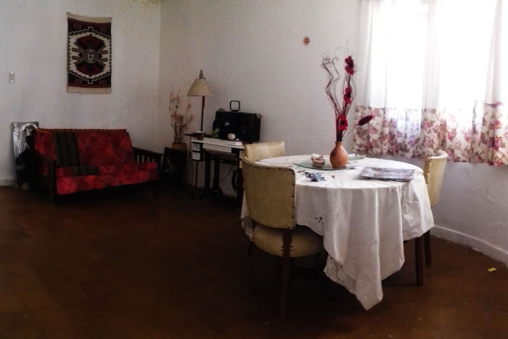 Sala privada anexa a la habitación, con mesa y sillón.