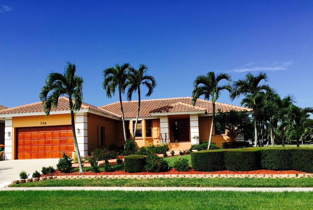 Front house surrounded with palms and fruit trees