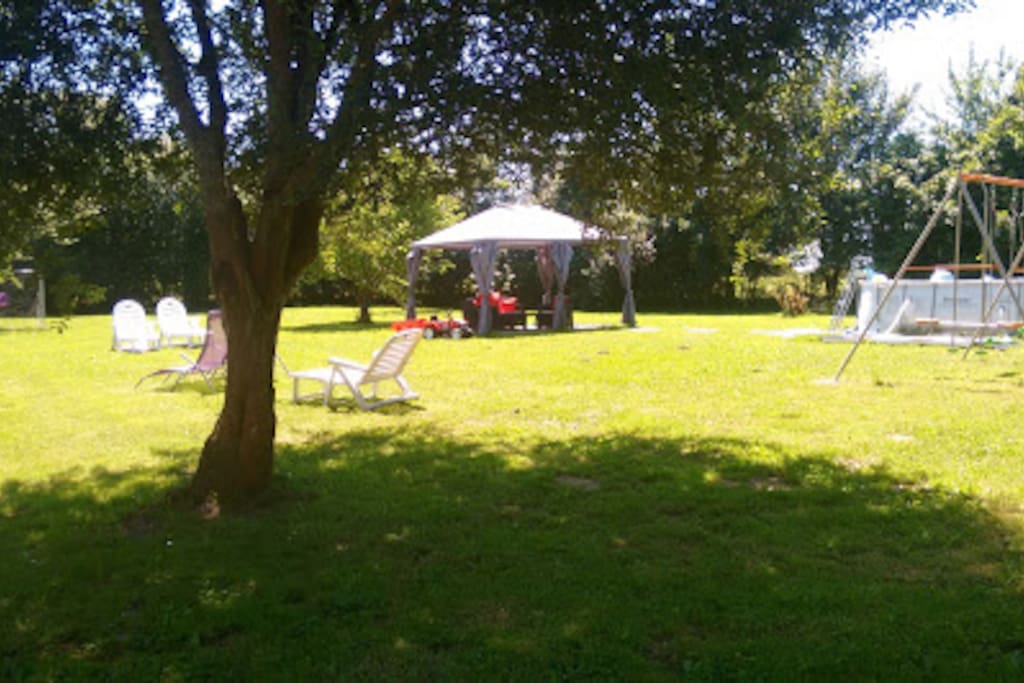 Shared leisure area with above ground splash pool, loungers and childrens' swings.