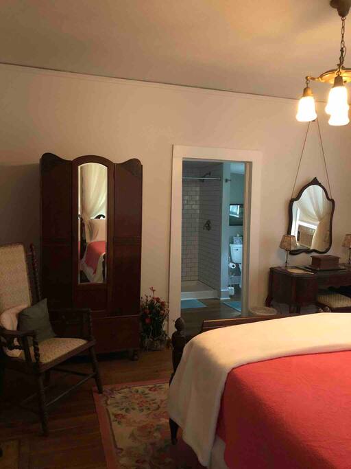 Spacious room and private bathroom with large shower, toilet and vanity on main level of house.