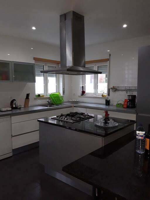 A cozinha está completamente renovada. Tem uma ilha, fogão com exaustor, uma zona de refeições, forno, microondas, máquina de lavar roupa e máquina de lavar louça.