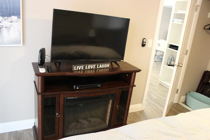 Телевизор и електричен камин во главната спална соба.