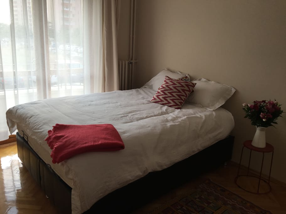 The bedroom which is cozy and simple.. The room is light with a small balcony.