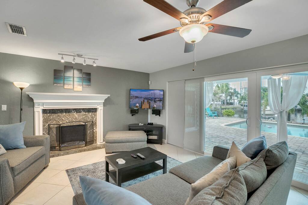 The living room has it all -- comfy seating, flat screen TV, decorative fireplace, and direct access to the gorgeous backyard.