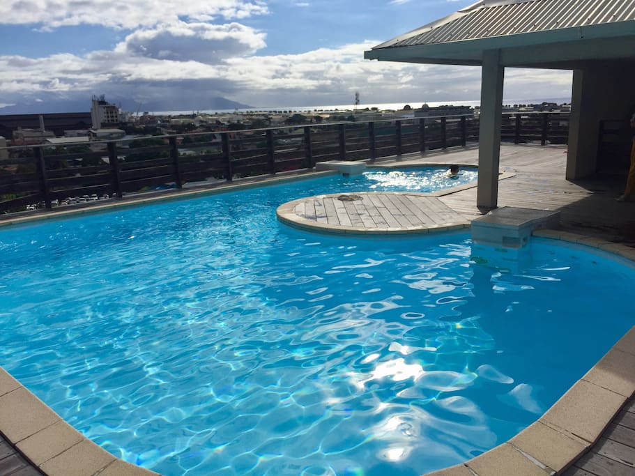 Piscine au dernier étage avec une vue panoramique sur la ville de Papeete.