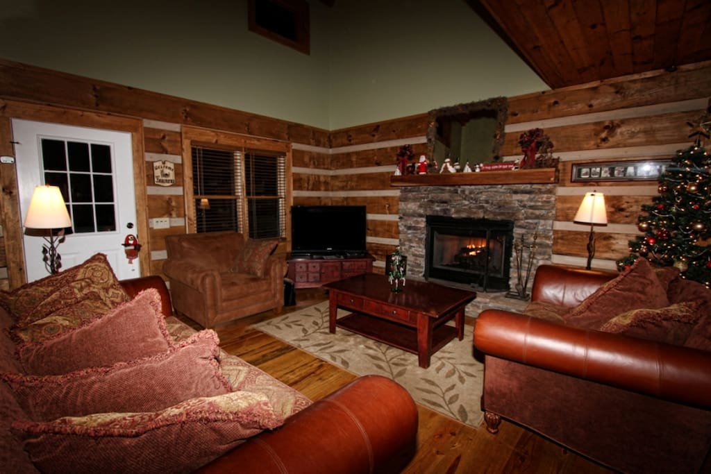 Cozy living area surrounding hand-stacked stone hand-stacked stone fireplace and 50" HD television.