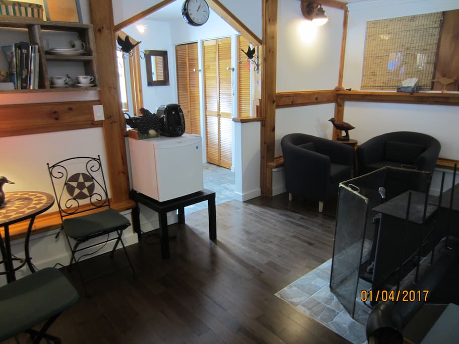 Salon attenant aux chambres avec une cafetière et frigo.