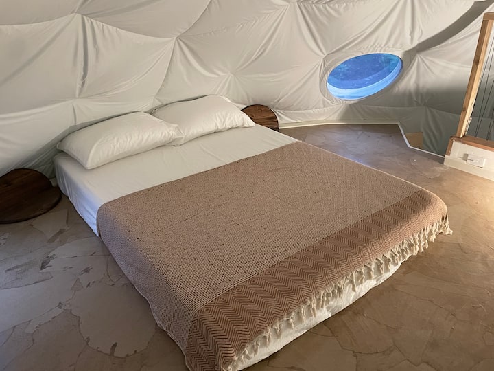 Queen size bed in the loft with standing-height head-room around the foot of the bed and railing for easy maneuverability. The loft also features Lutsen mountain sunset views out the porthole windows.