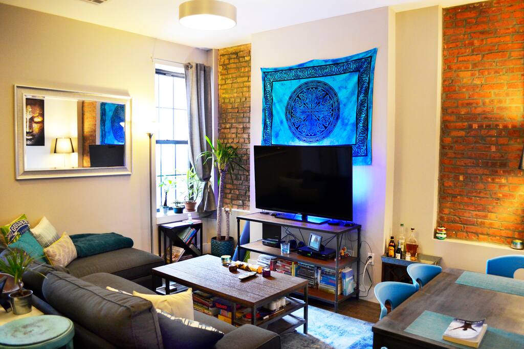 Spacious yet cozy living room with a 10ft L-couch, large coffee table, and four-person dining table.