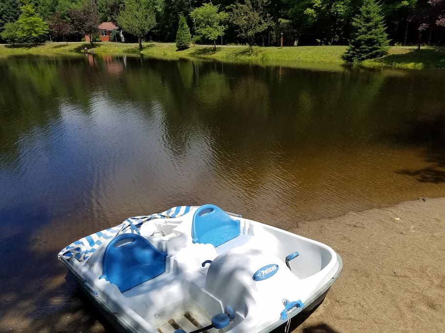 And a paddle boat in swimming water with sandy beach.
