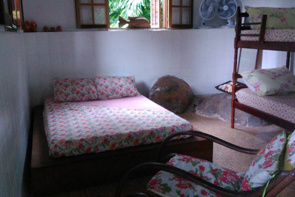 Suíte com a cama japonesa, beliche, cadeira de balanço e ventiladores.