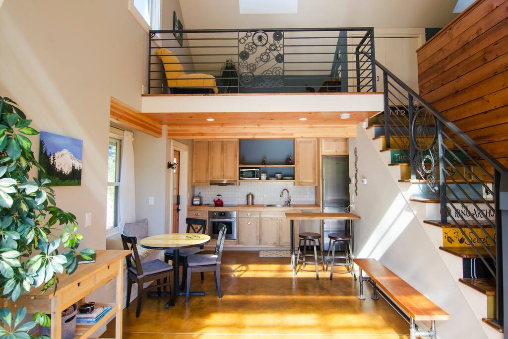 The downstairs main area is an open & airy kitchen and dining room. Stairs lead up to the loft area.
