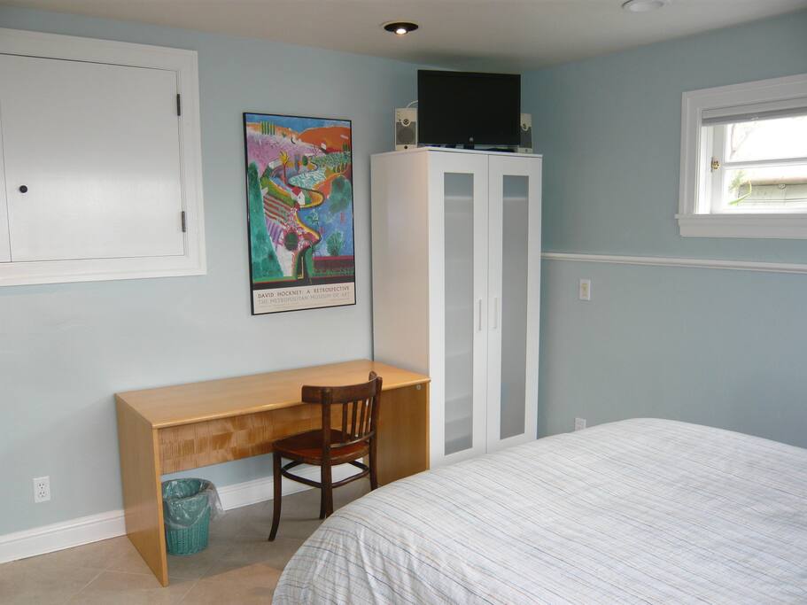 Desk for computer, TV, and armoire for clothing.