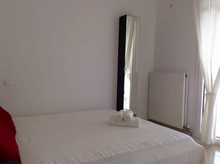 La cama doble y el pequeño espejo del armario.