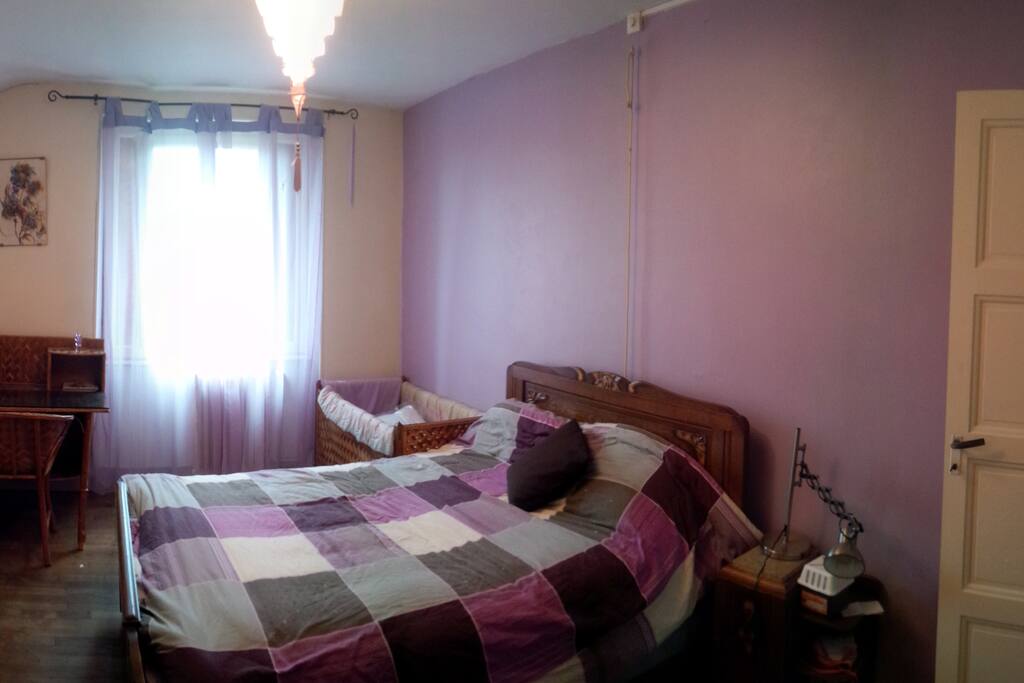 Première grande chambre avec un lit double, avec un bureau et une penderie. De plus un lit pour bébé est à disposition