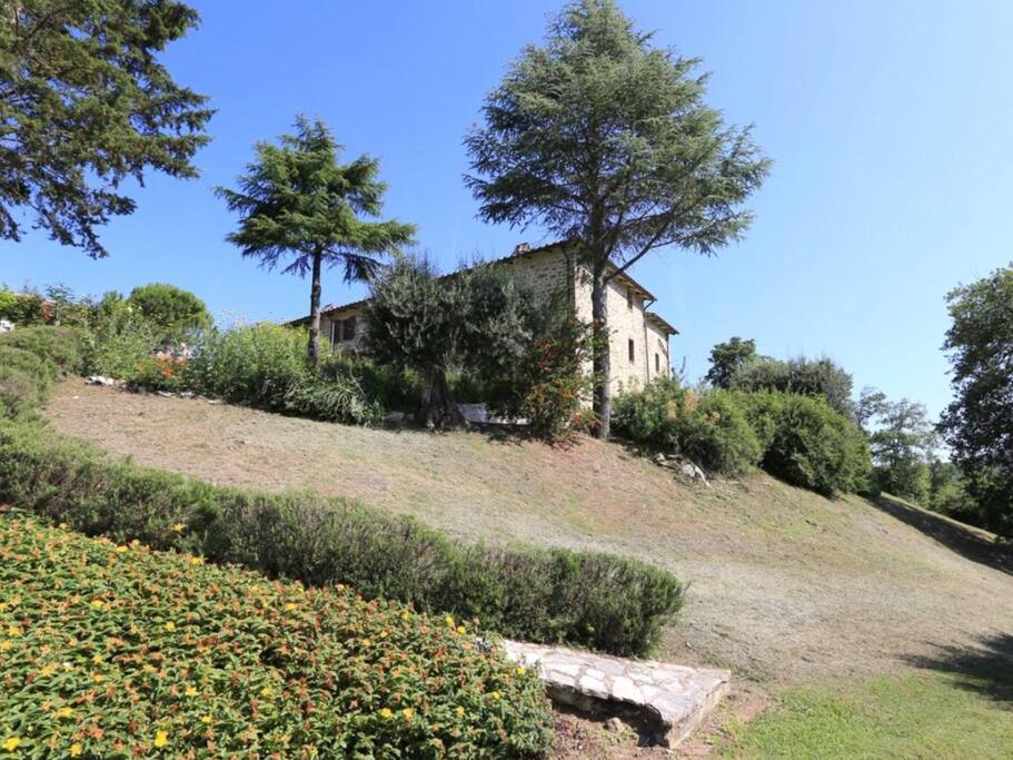 The farmhouse. Crinale apartment is shown here on the second floor with far reaching views over the olive grove and Umbrian hills