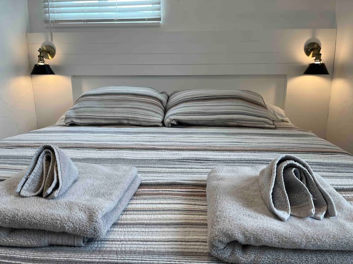 Spálne s manželskou posteľou v Kalifornii s nočnými stmievačmi a nabíjacími zásuvkami.