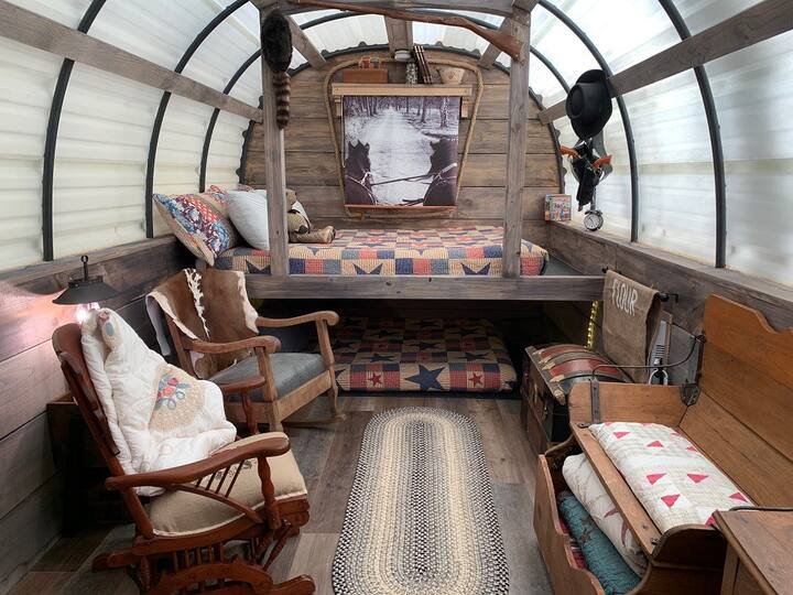 Queen Bed is top and Full bed is bottom...... Come cozy up as you cross the prairie! (TV is hidden behind the roll up shade)