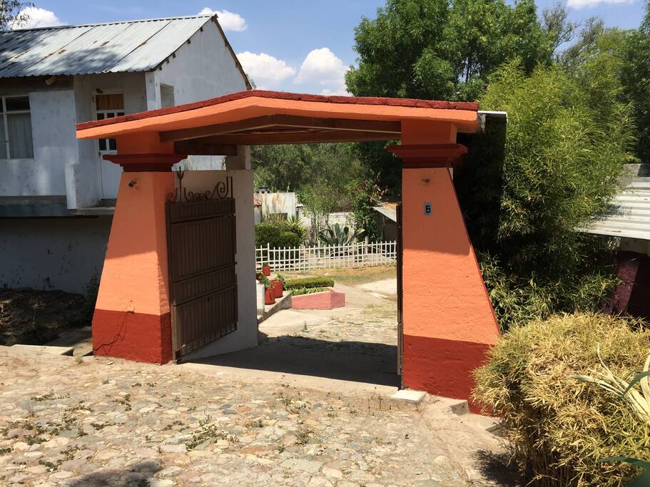 Frente del Hotel Hacienda del Marques, encontrarás un camino empedrado que te conducirá al final a este portón que es la entrada de la casa.