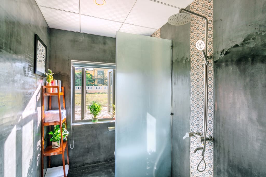 Bathroom with bathtowel, shower, hot warter, shampoo, bath gel, plants open window with curtain