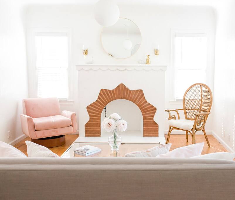 Stylish pink modern chair & rattan chair are statement home decor pieces in this cheery home.