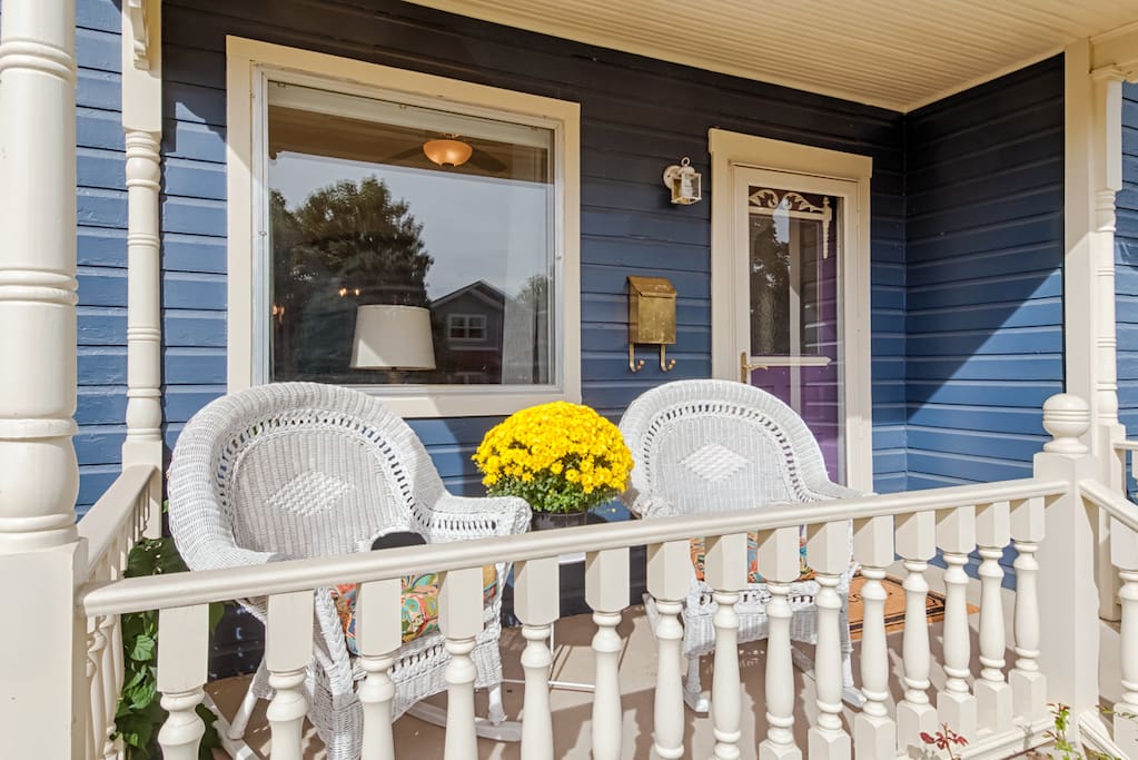 Covered front porch with wicker rockers perfect for relaxing and watching the world go by.