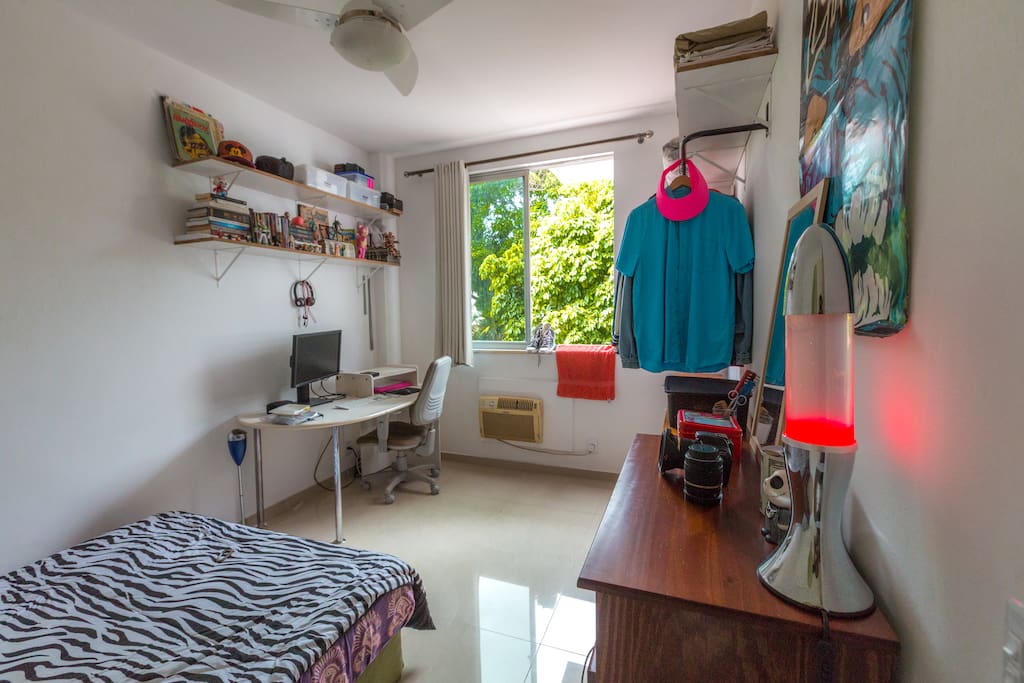 Quarto espaçoso com mesa de trabalho.