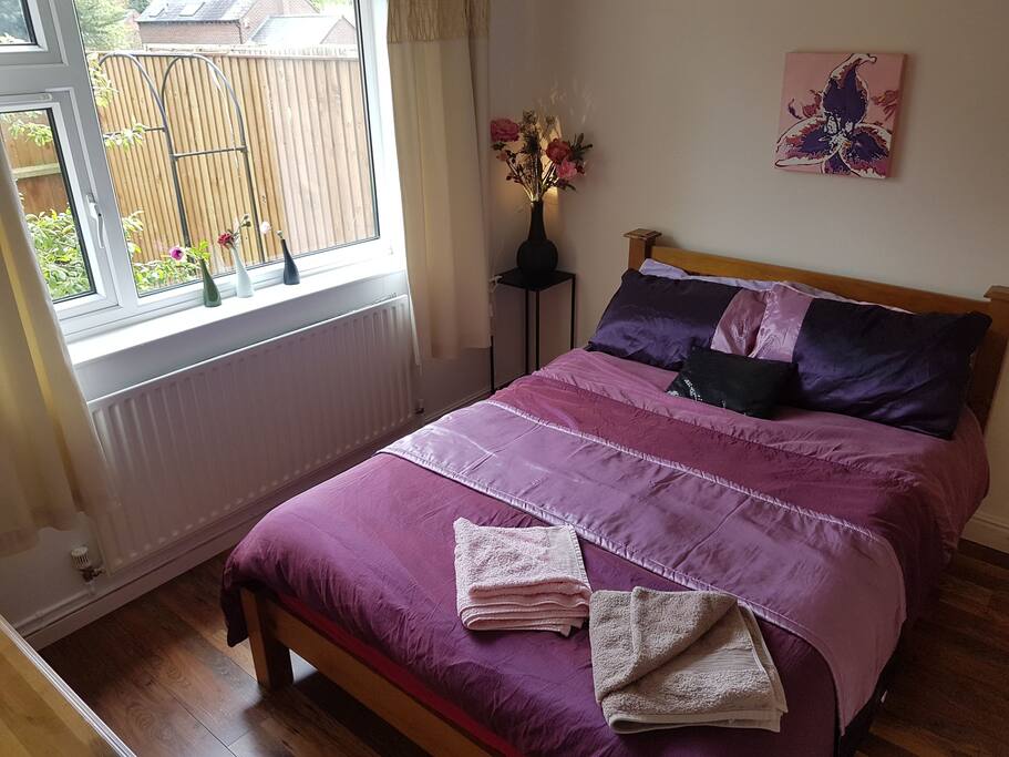 Double bedroom with a comfortable wooden double bed, wardrobes and a chest of draws.