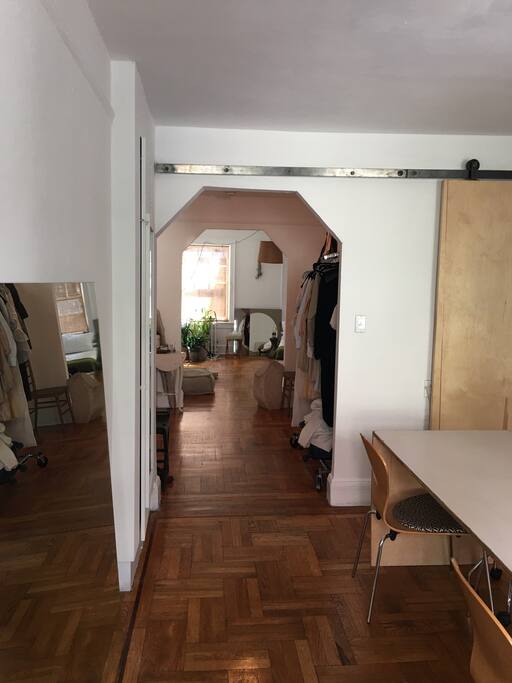 Open floor-through design. View from office into foyer/entrance and into bedroom. Sliding door to closet also closes off office from foyer if desired.