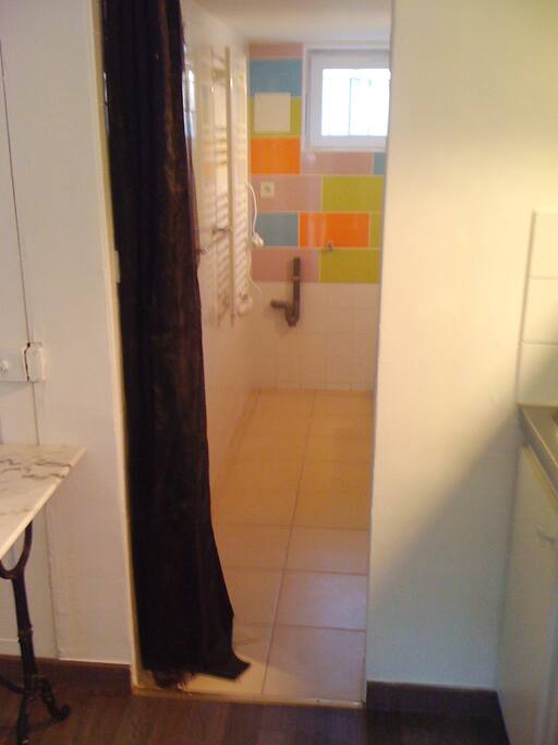 Acces à la salle de douche + toilettes (ferme avec un rideau)