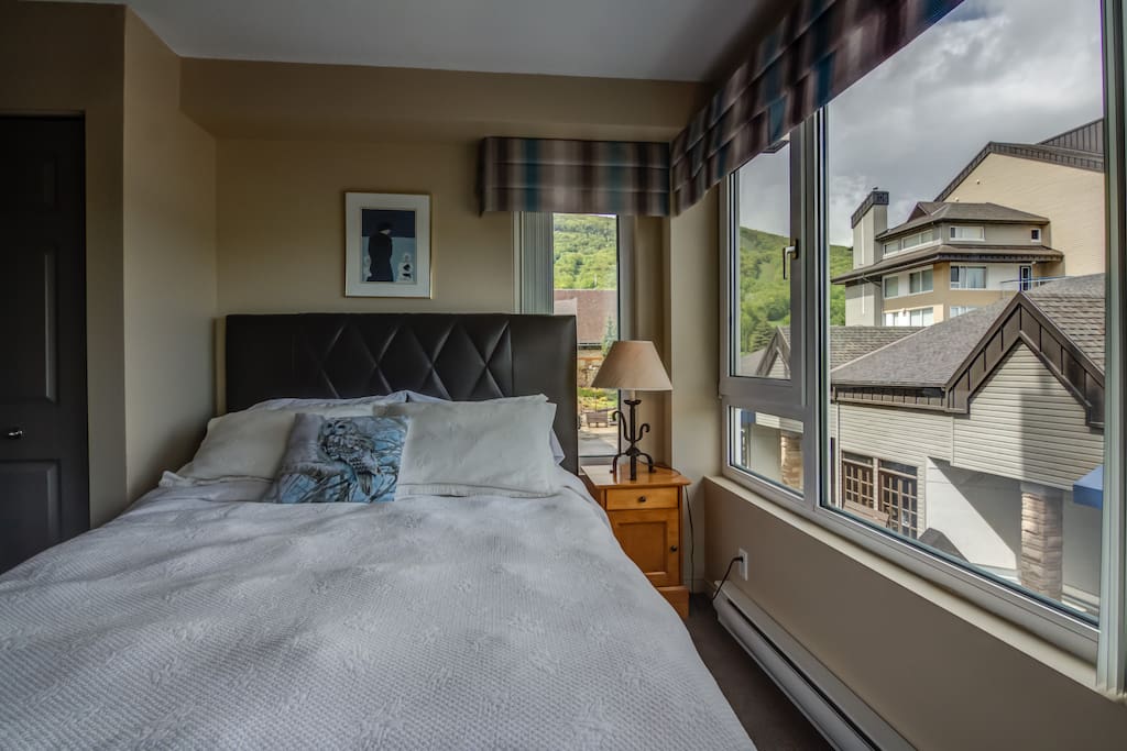 La montagne comme vue au Condo Alpin du Mont Sainte-Anne. Directement au pied des pentes, vous passerez le meilleur des séjours! Ici la chambre des maîtres avec lit Queen.