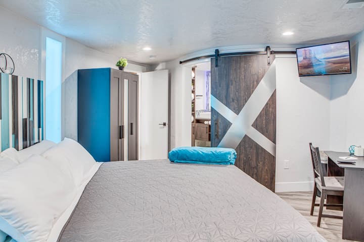 Master bedroom with ensuite, desk, closet for storing your belongings, and 32" Vizio smart tv. Curved barn door allows privacy and separation between the two spaces.