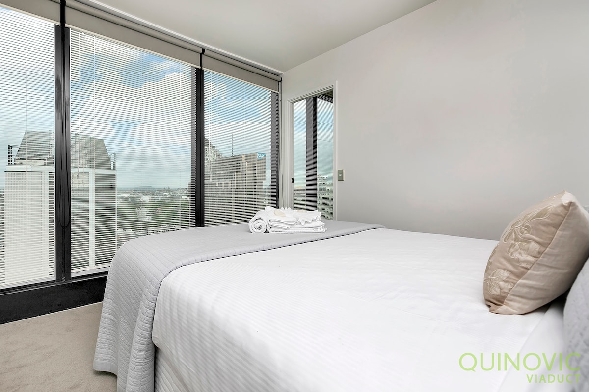 Acogedor dormitorio con ventanas del piso al techo: disfruta de una noche de sueño reparador en este dormitorio sereno, completo con vistas panorámicas a la ciudad y muebles elegantes.