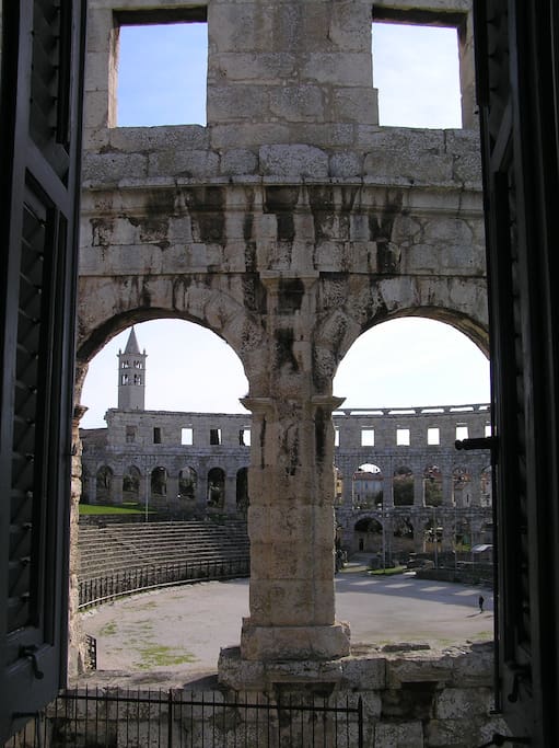 Arena Pula and in the background the bell tower of the church of St. Anthony of Padua in Pula with 45 m high tower. from the 1930s.