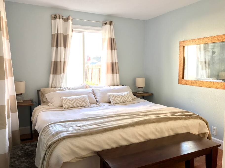 The bedroom, with medium-firm latex and memory foam king bed, down pillows, down comforter, cotton bed linens, and blackout curtains. The king bed can be split into two singles.