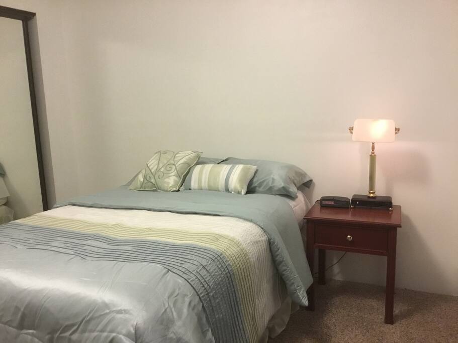 Nice, clean bed in large room.