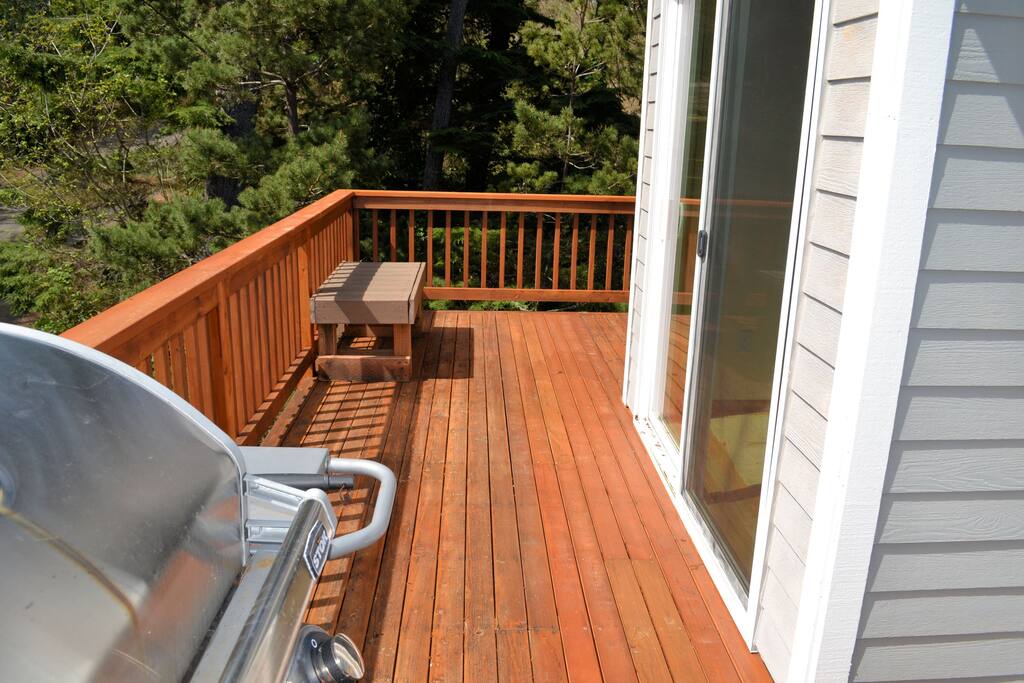Upper deck off living area with a bench seat and gas BBQ