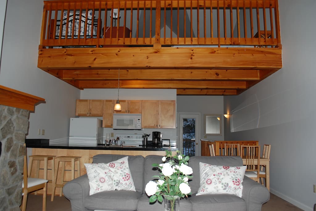 Great room looking into kitchen with loft above