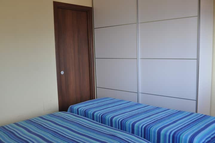 QUARTO COM CLOSET, TELEVISÃO, BANHEIRO E TERRAÇO EQUIPADO COM VISTA PARA O MAR