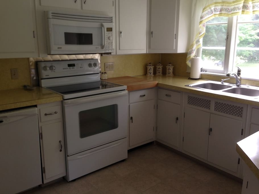 Kitchen with electric stove, microwave, dishwasher, garbage disposal