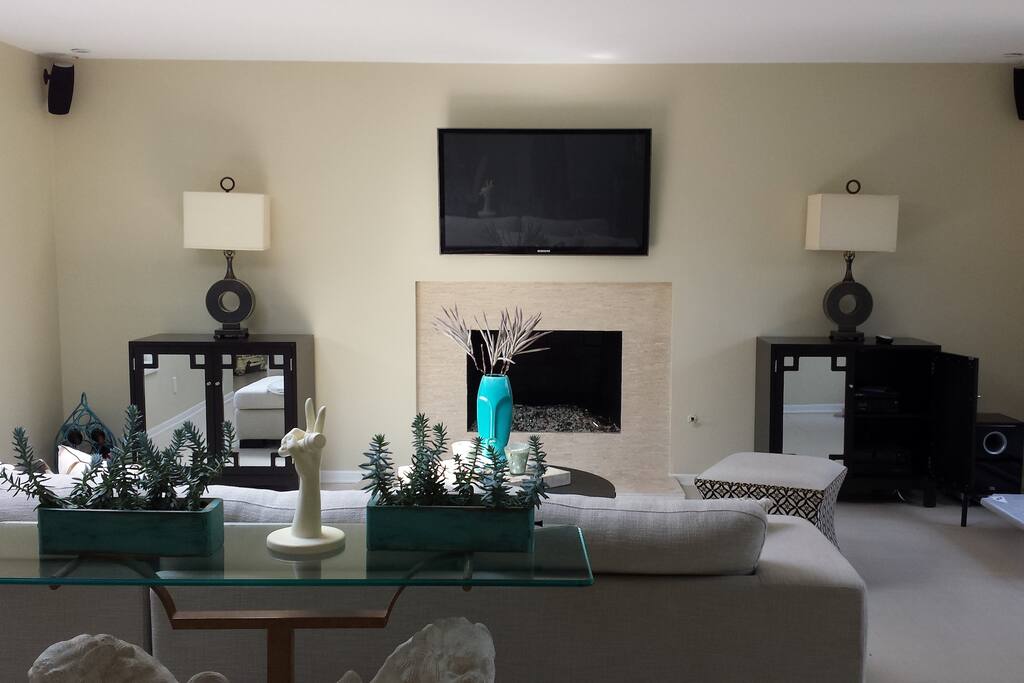 Open living room with big screen TV and gas fireplace.