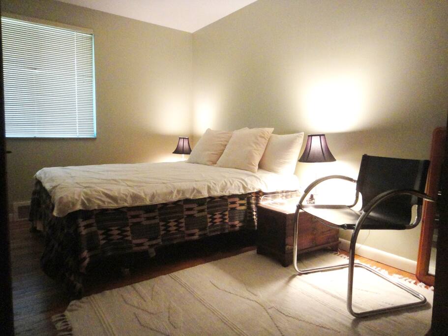 The cozy guest room has a comfortable queen bed .