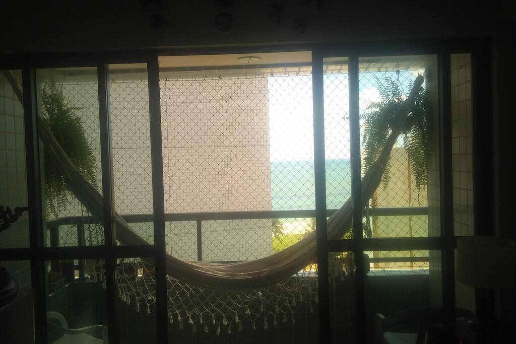 Varanda com clima de praia. plantas, velas, cadeiras e redes. Aproveite!