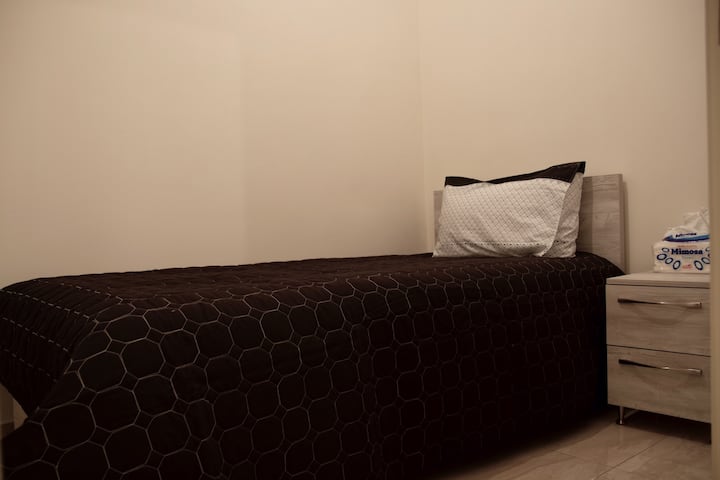 Chumba kimoja cha kulala chenye kitanda kikiwemo kabati la ukutani lenye viango, taulo na kabati la kuweka vitu 