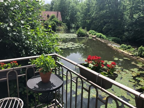 Secluded cottage on a river below a medieval town
